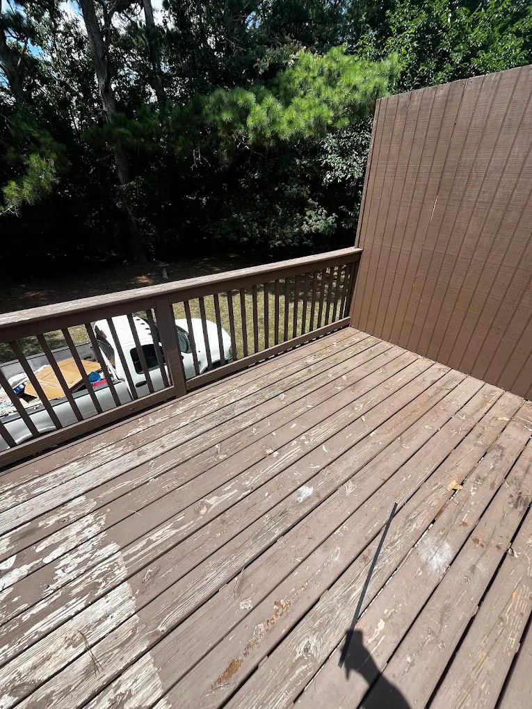 The same back deck emptied, with the boards swept clear from the railing to the fence